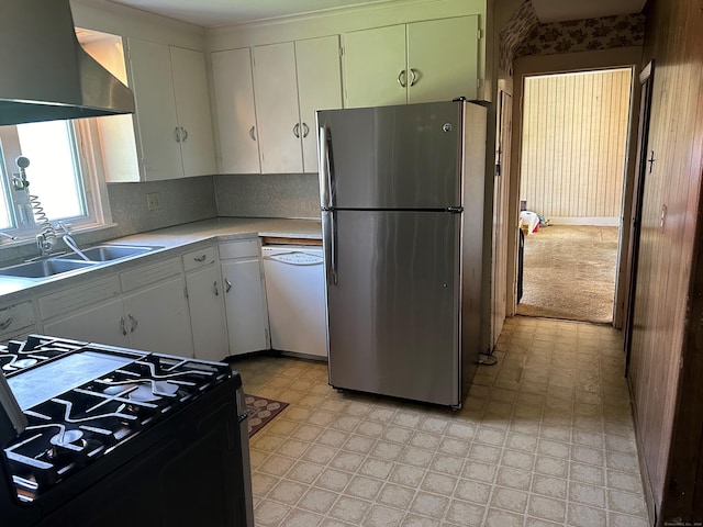 kitchen with white cabinets, black range oven, white dishwasher, sink, and stainless steel fridge