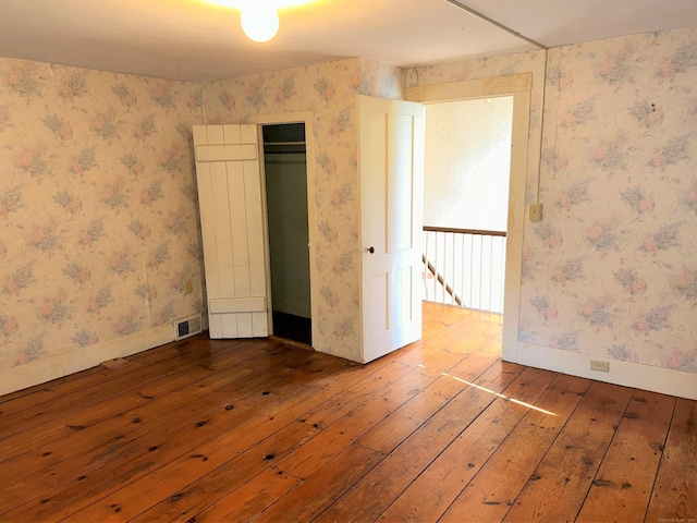 unfurnished bedroom featuring wood-type flooring and a closet