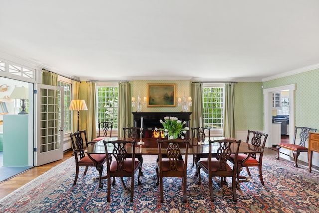 dining area featuring wood-type flooring, plenty of natural light, and ornamental molding