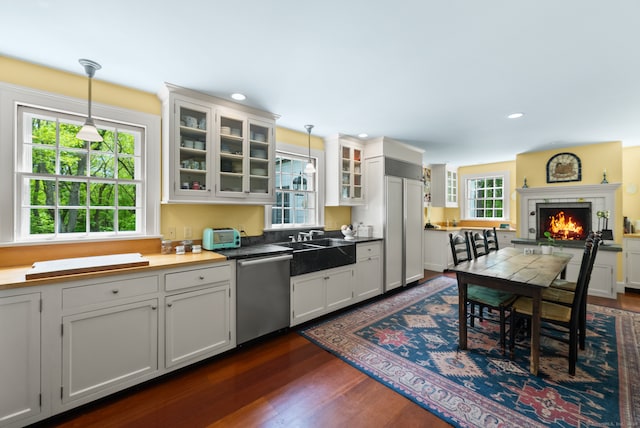 kitchen featuring a wealth of natural light, white cabinets, dishwasher, and dark hardwood / wood-style flooring