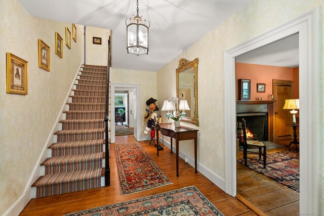 foyer entrance with an inviting chandelier and hardwood / wood-style flooring