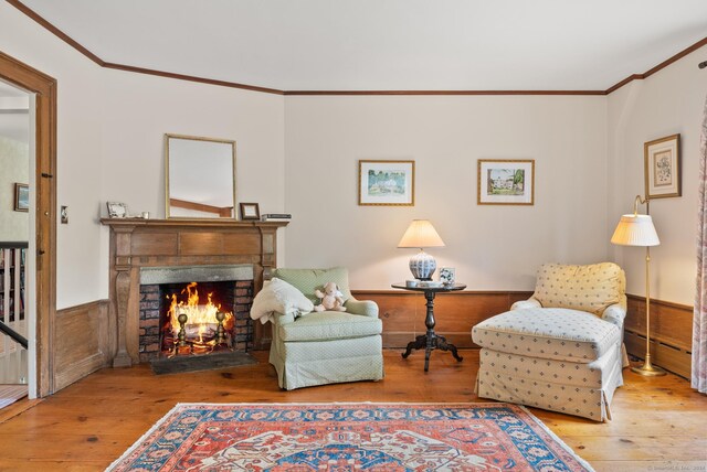 sitting room with hardwood / wood-style floors and crown molding