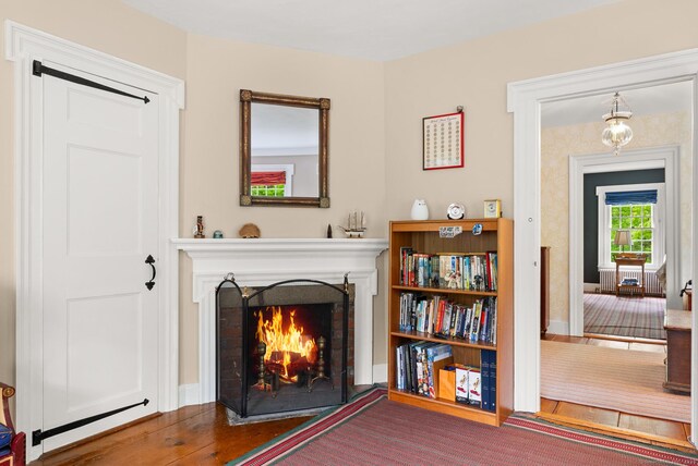 interior space featuring a brick fireplace and hardwood / wood-style flooring