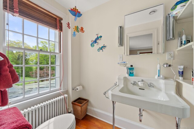 bathroom with sink, radiator, toilet, and hardwood / wood-style floors