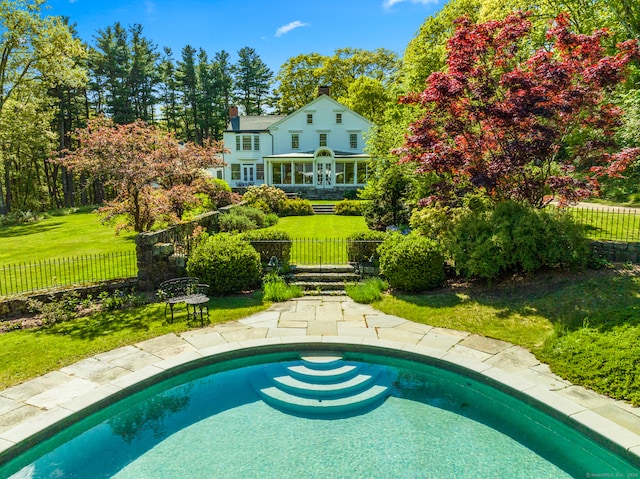 view of swimming pool featuring a lawn