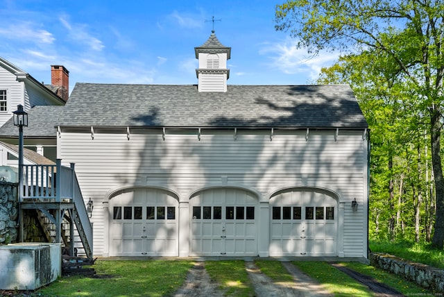 back of house with a wooden deck and a garage