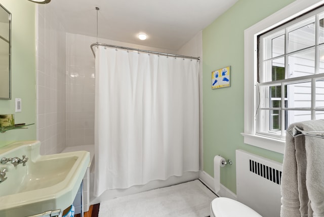 bathroom with sink, radiator, and toilet