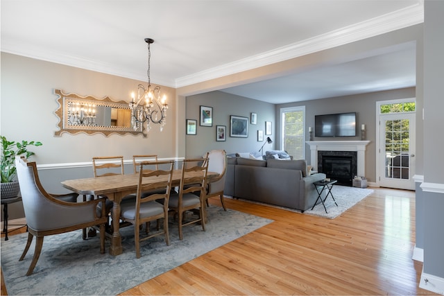 dining room with a chandelier, light hardwood / wood-style floors, and crown molding