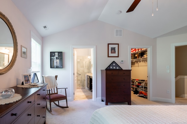 carpeted bedroom featuring ensuite bath, a spacious closet, a closet, ceiling fan, and vaulted ceiling