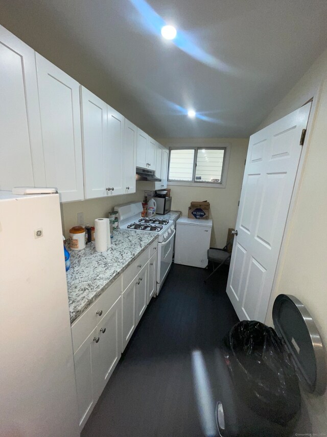 kitchen with light stone counters, white cabinets, and white appliances