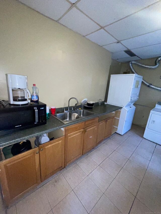 kitchen featuring washer / dryer, a paneled ceiling, sink, and light tile floors