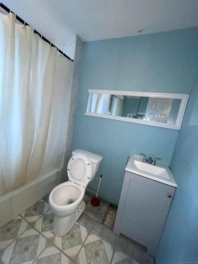 full bathroom with tile flooring, shower / tub combo, vanity, and toilet