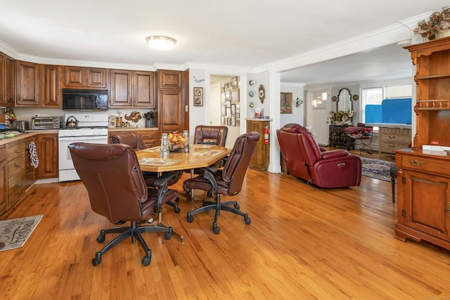 dining area with light wood-type flooring and crown molding