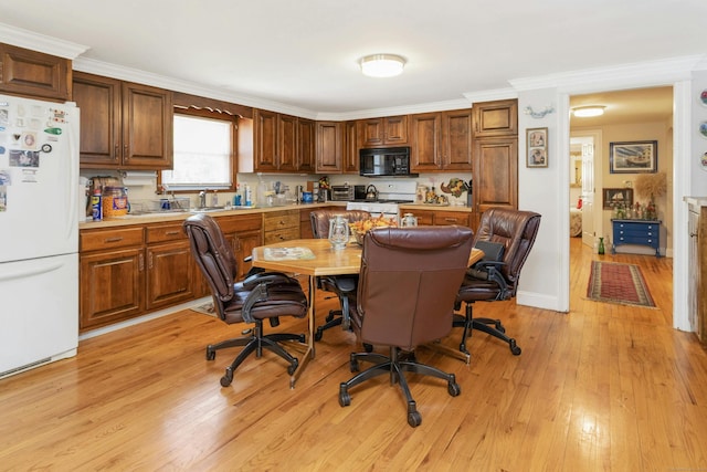 kitchen with light hardwood / wood-style flooring, built in desk, white appliances, and ornamental molding