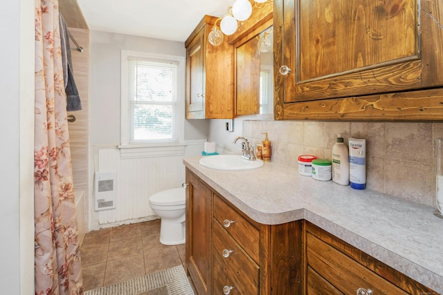 full bathroom with vanity, toilet, shower / bath combo, heating unit, and tile patterned flooring