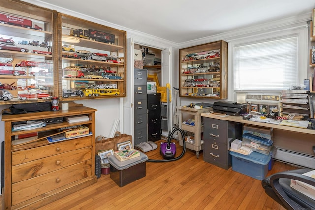 office space featuring ornamental molding, a baseboard heating unit, and light hardwood / wood-style floors