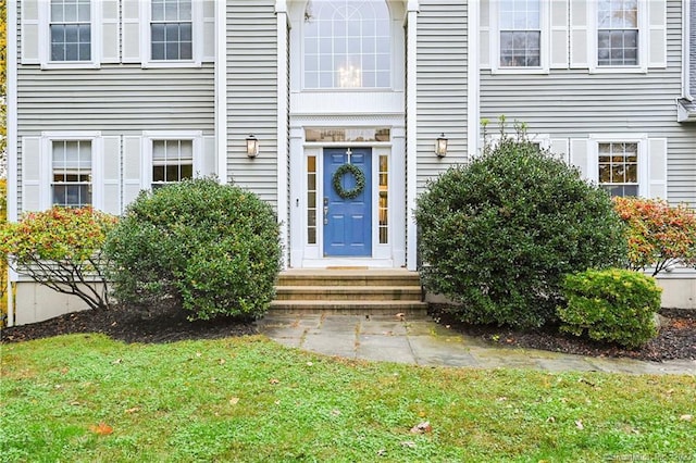 view of exterior entry with a yard