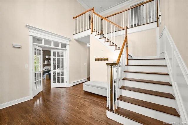 stairway with hardwood / wood-style flooring, french doors, ornamental molding, and a baseboard heating unit