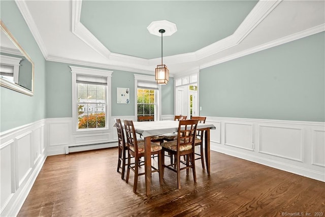 dining area featuring baseboard heating, a tray ceiling, dark hardwood / wood-style floors, and ornamental molding