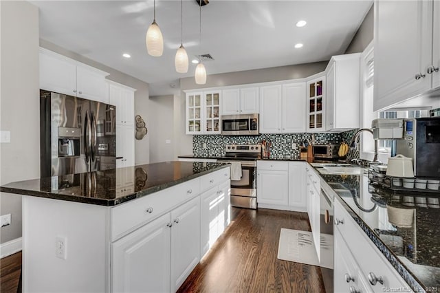 kitchen with white cabinetry, stainless steel appliances, and a kitchen island