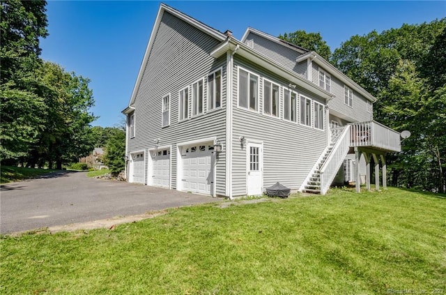 view of side of home featuring a garage, a yard, and a wooden deck