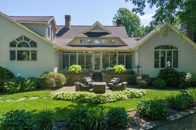 back of house featuring an outdoor living space, a yard, a sunroom, and a patio area