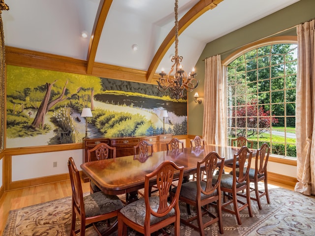 dining area with lofted ceiling with beams, hardwood / wood-style floors, and a notable chandelier