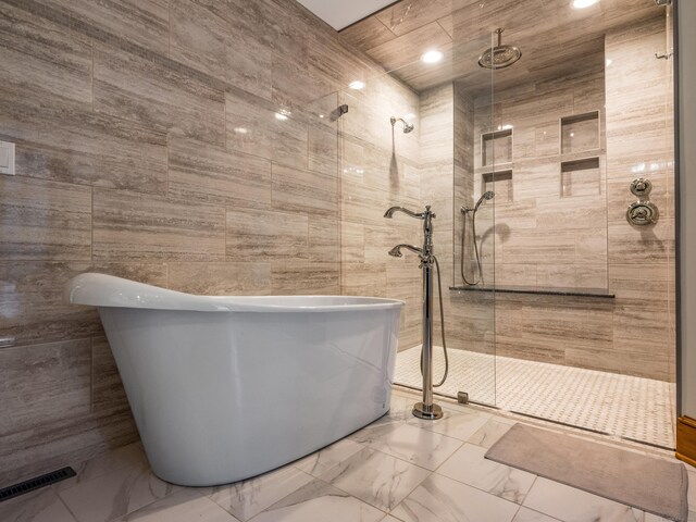 bathroom featuring independent shower and bath and tile walls