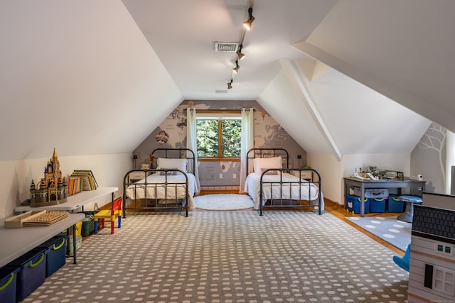 carpeted bedroom featuring vaulted ceiling and rail lighting