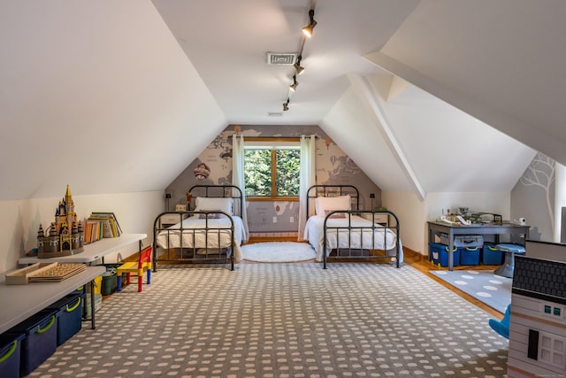 bedroom with lofted ceiling and track lighting