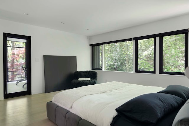 bedroom with access to outside and light hardwood / wood-style floors