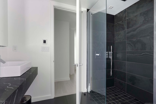 bathroom featuring vanity, tile patterned flooring, and a tile shower