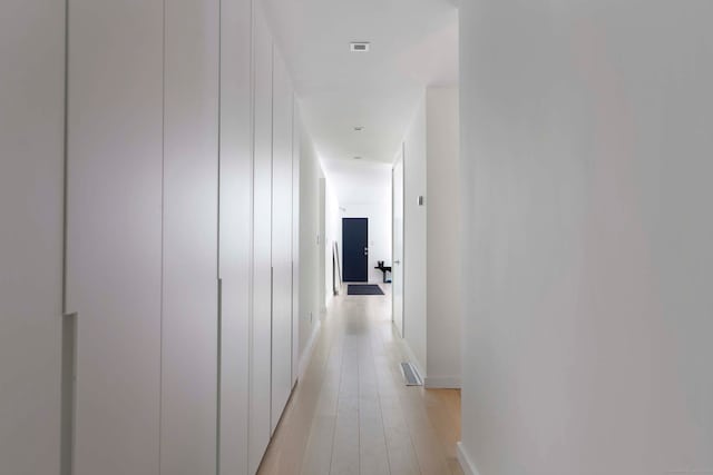 corridor with light hardwood / wood-style floors