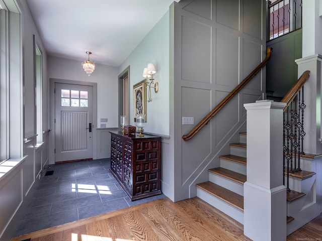 entryway with hardwood / wood-style flooring and a chandelier