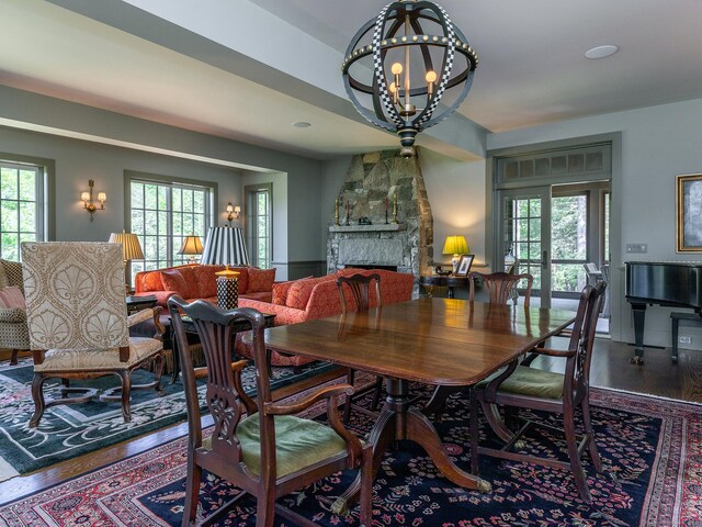 dining area featuring a chandelier, hardwood / wood-style flooring, and a fireplace