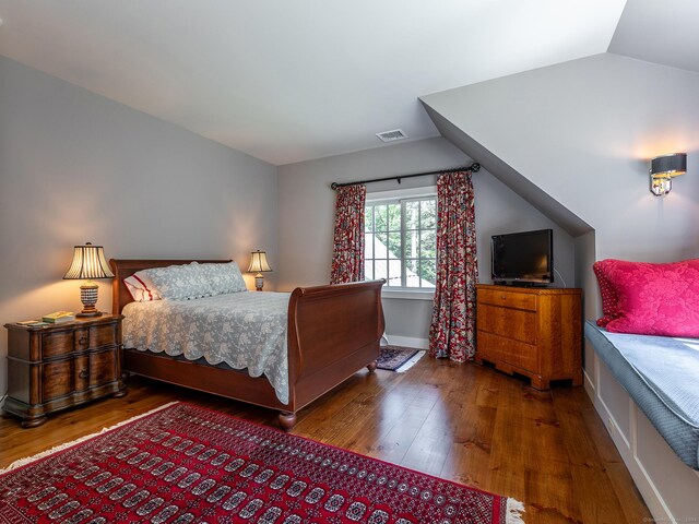 bedroom featuring hardwood / wood-style floors and vaulted ceiling