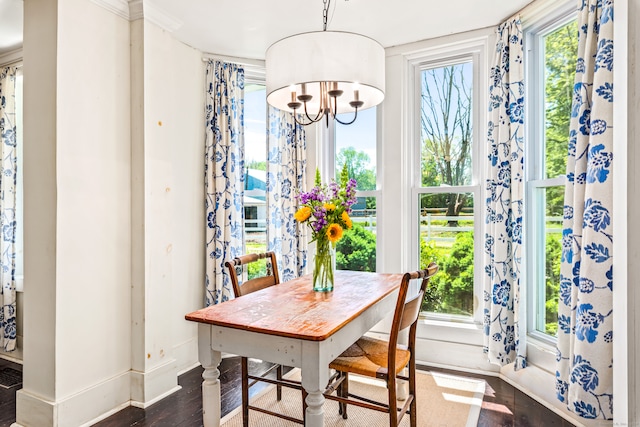 dining area featuring dark wood-type flooring and a notable chandelier