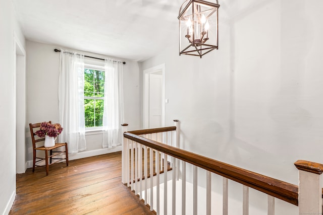 stairway featuring hardwood / wood-style flooring and a notable chandelier