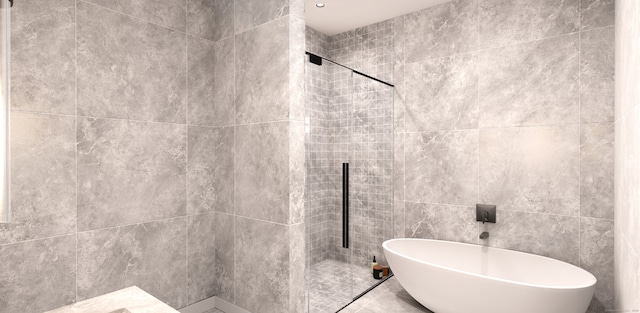 bathroom featuring a tile shower, tile floors, and tile walls