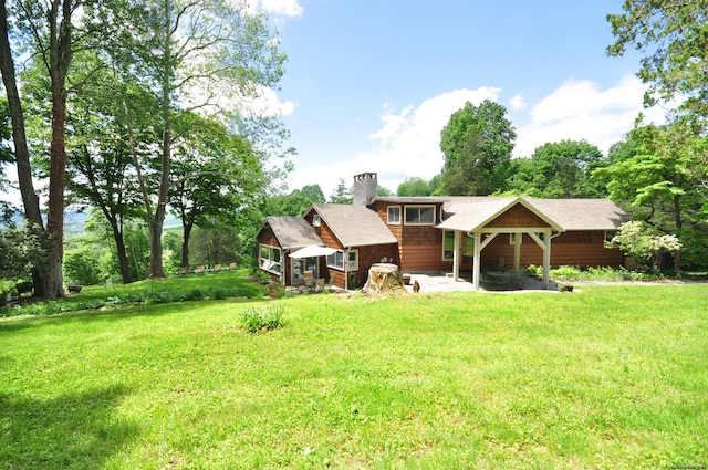 back of property featuring a yard and a chimney