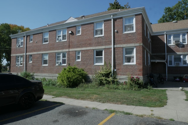 view of property featuring cooling unit and uncovered parking
