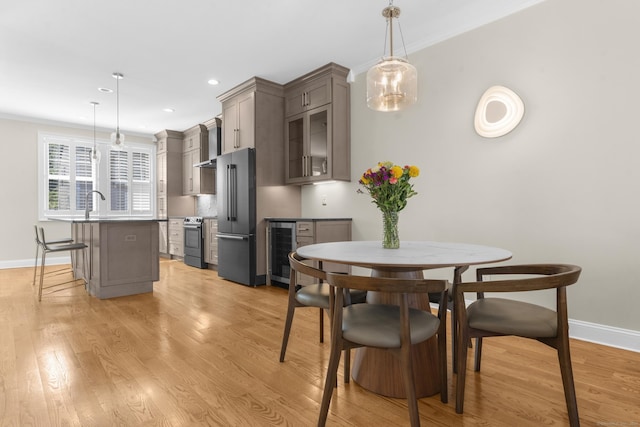 30 Village Xing Unit 30, East Lyme, CT 06357 - dining room with beverage cooler, a dry bar, light wood-style flooring, crown molding, and recessed lighting