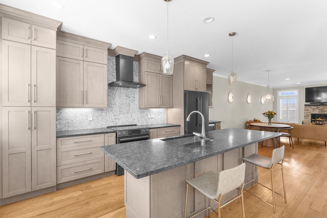30 Village Xing Unit 30, East Lyme, CT 06357 - kitchen with stainless steel appliances, wall chimney range hood, a breakfast bar, light wood finished floors, and tasteful backsplash