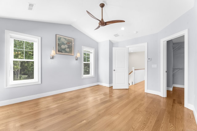 30 Village Xing Unit 30, East Lyme, CT 06357 - unfurnished bedroom with multiple windows, lofted ceiling, light wood finished floors, a walk in closet, and ceiling fan