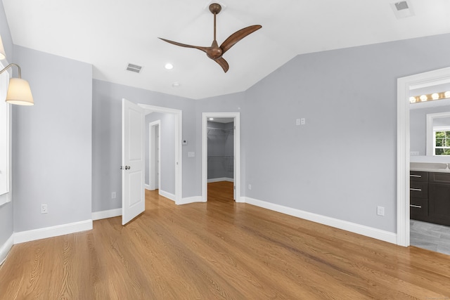 30 Village Xing Unit 30, East Lyme, CT 06357 - unfurnished bedroom with a spacious closet, light wood-style flooring, vaulted ceiling, a closet, and ensuite bathroom