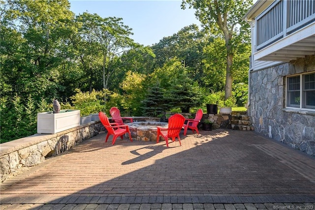 view of patio / terrace with a balcony and a fire pit