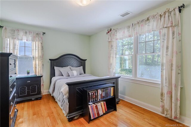 bedroom featuring light hardwood / wood-style floors and multiple windows