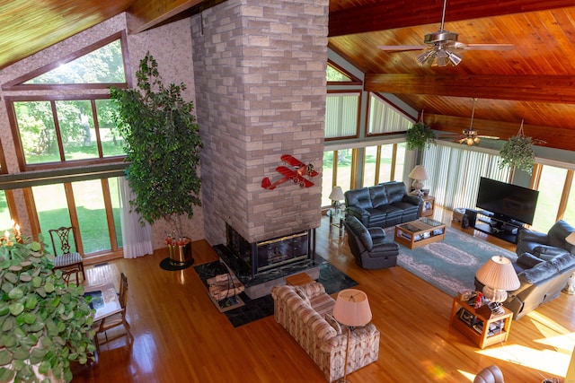 living room featuring high vaulted ceiling, a healthy amount of sunlight, ceiling fan, and hardwood / wood-style floors