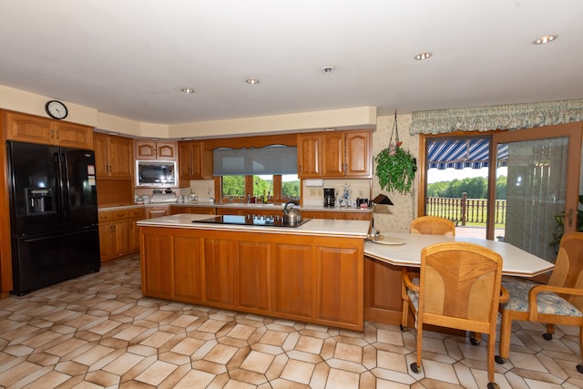 kitchen with black appliances and light tile floors