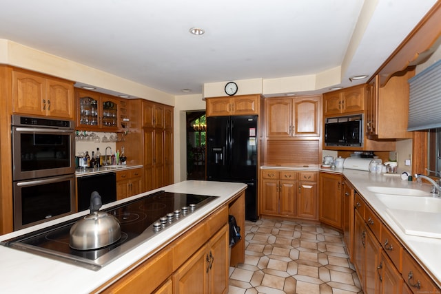 kitchen with black appliances, sink, and light tile floors